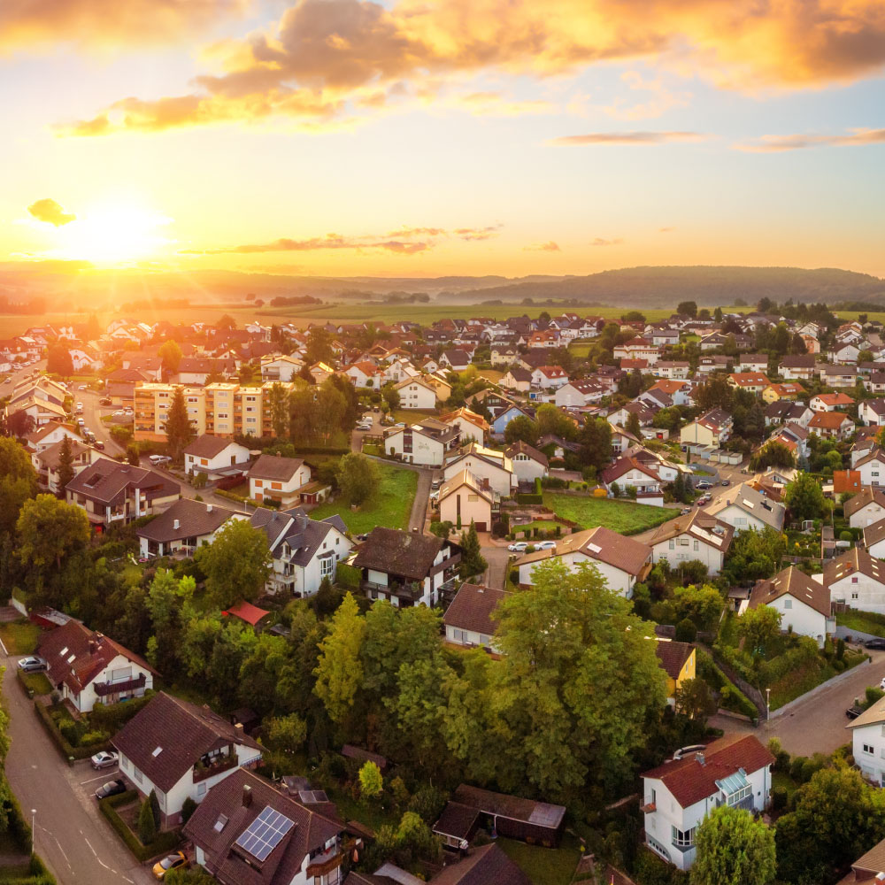 Aerial panorama of a small town at sunrise, with magnificent colourful sky and warm light