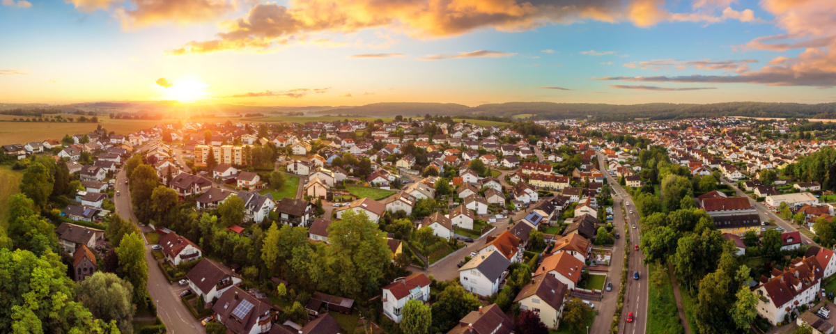 Aerial panorama of a small town at sunrise, with magnificent colourful sky and warm light