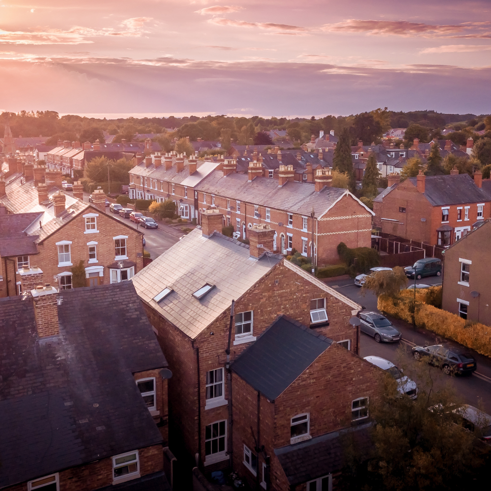 Sun setting with atmospheric effect over traditional British houses and tree lined streets