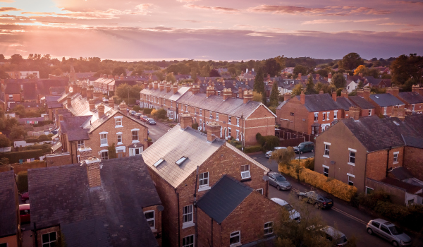 Sun setting with atmospheric effect over traditional British houses and tree lined streets
