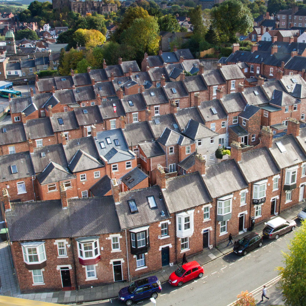 A view from above , looking down onto rows of tightly packed terraced houses on the city streets of Durham, UK