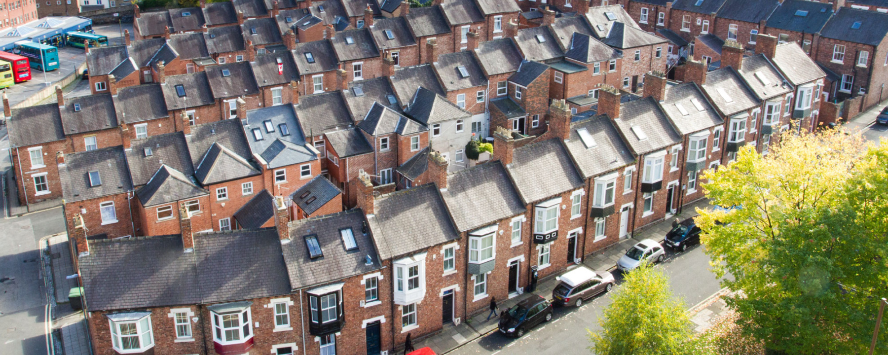 A view from above , looking down onto rows of tightly packed terraced houses on the city streets of Durham, UK