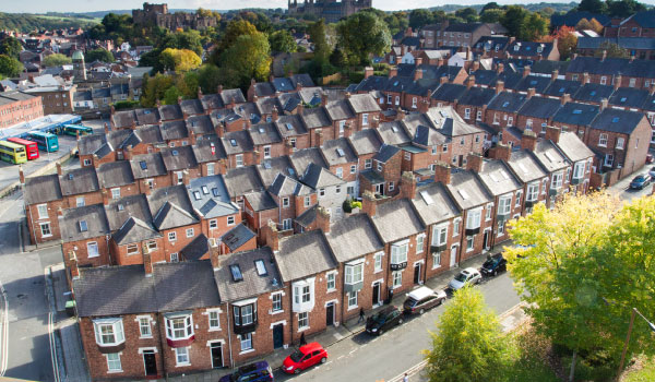 A view from above , looking down onto rows of tightly packed terraced houses on the city streets of Durham, UK